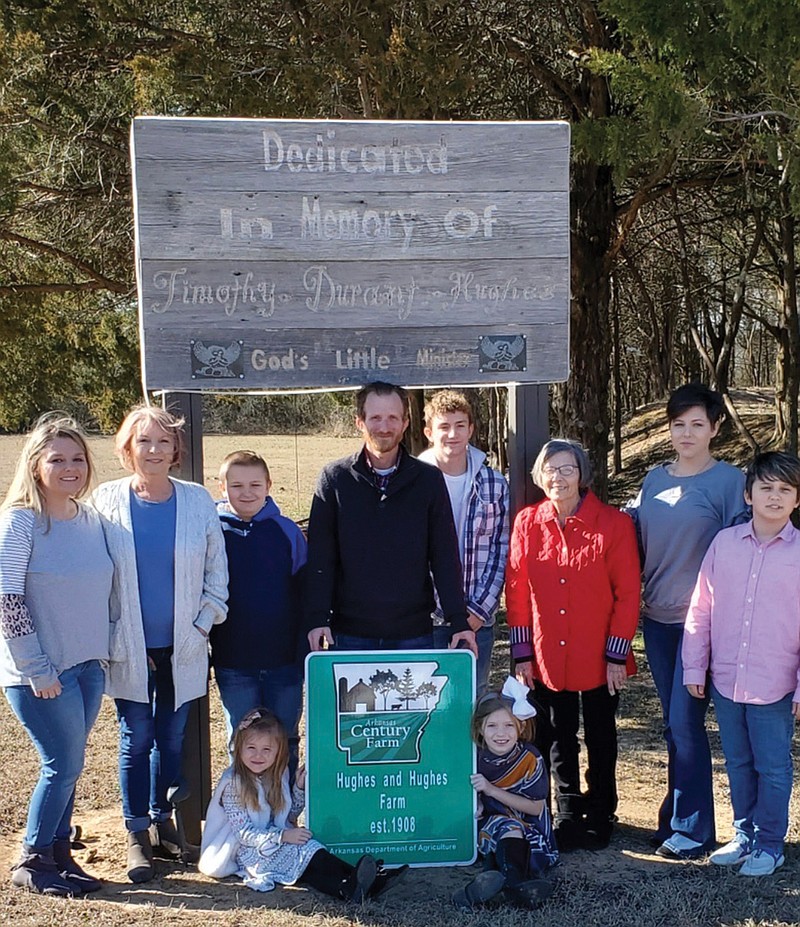 The Hughes and Hughes Farm of Romance has been named a 2020 Arkansas Century Farm. Shown with the official sign from the Arkansas Century Farm program are, sitting, Addialee Hughes, 6, left, and Lilly Hughes, 9; and standing, from left, Tiffany Holeman; Lisa Hughes; Jonathan Holeman, 9; Timothy Hughes; Nickolas Holeman, 15; Myrtle Hughes; Stevie Hughes; and Jude Hughes, 11. Not shown are Dustin Holeman and Bowen Law, 8. The group is gathered on land that has been dedicated to the memory of the late Timothy “Timmy” Durant Hughes, who died at the age of 4 with leukemia on July 22, 1969.