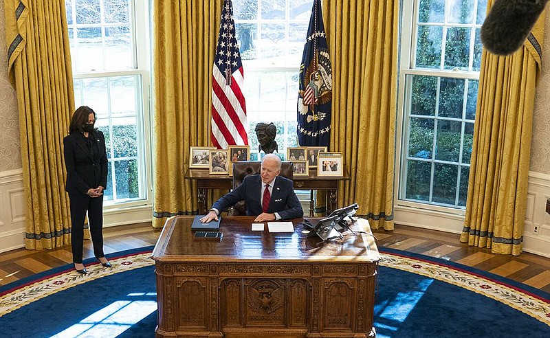 President Joe Biden signs executive orders Thursday in the Oval Office intended to strengthen Americans’  access to health care. “There’s nothing new that we’re doing here other than restoring the Affordable Care Act and restoring Medicaid to the way it was before [Donald] Trump became president,” Biden said. Vice President Kamala Harris watches at left. More photos at arkansasonline.com/129dc/.
(The New York Times/Doug Mills)