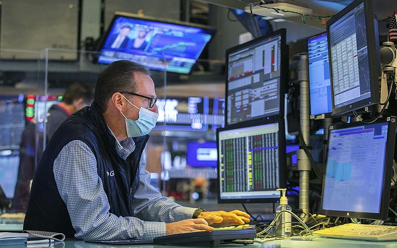 A specialist works at his post on the floor of the New York Stock Exchange on Thursday. Stocks closed broadly higher a day after sinking to their worst loss since October. The government reported Thursday that the U.S. economy contracted 3.5% in 2020, and the outlook for 2021 remains hazy.
(AP/New York Stock Exchange/Courtney Crow)
