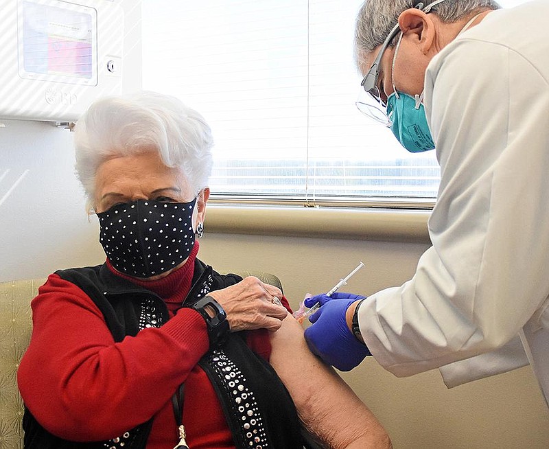 Elizabeth Dunn receives her first coronavirus vaccine shot from Dr. Stewart Greenberg on Friday, Jan. 29, 2021 at the UAMS vaccine clinic in the Freeway Medical Tower in Little Rock. (Arkansas Democrat-Gazette/Staci Vandagriff)