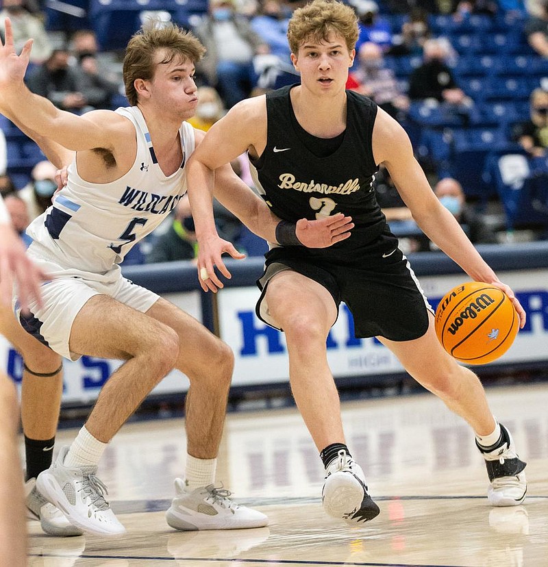 Abel Hutchinson (right) of Bentonville drives to the basket against Mack Wright of Springdale Har-Ber on Friday at Wildcat Arena in Springdale. Bentonville remained undefeated in the 6A-West with a 53-46 victory.
(Special to NWA Democrat-Gazette/David Beach)
