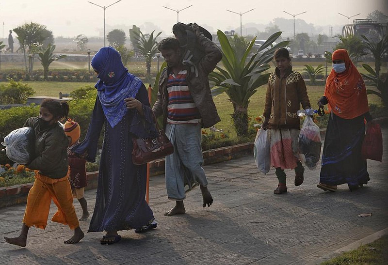 Rohingya refugees carry their belongings to a naval vessel Saturday as they’re relocated to the Bangladeshi island of Bhasan Char. More photos at arkansasonline.com/131rohingya/.
(AP/Azim Aunon)