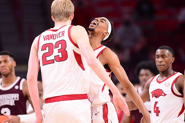 Arkansas guard Jalen Tate (facing) celebrates with forward Connor Vanover during a game against Mississippi State on Tuesday, Feb. 2, 2021, in Fayetteville. 