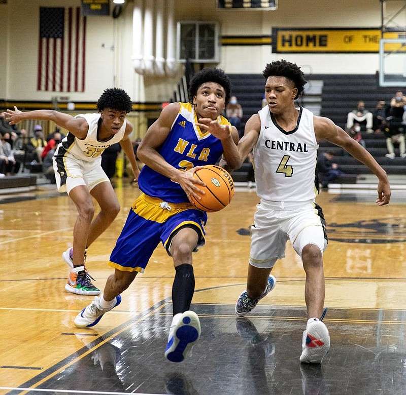 North Little Rock’s guard D.J. Smith (middle) drives the ball past Central’s guard Bryson Warren (right) Tuesday night at Central High School in Little Rock. (Arkansas Democrat-Gazette/Justin Cunningham)