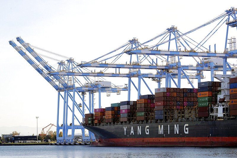 FILE - In this Nov. 4, 2019, file photo, cargo cranes are used to take containers off of a Yang Ming Marine Transport Corporation boat at the Port of Tacoma in Tacoma, Wash.