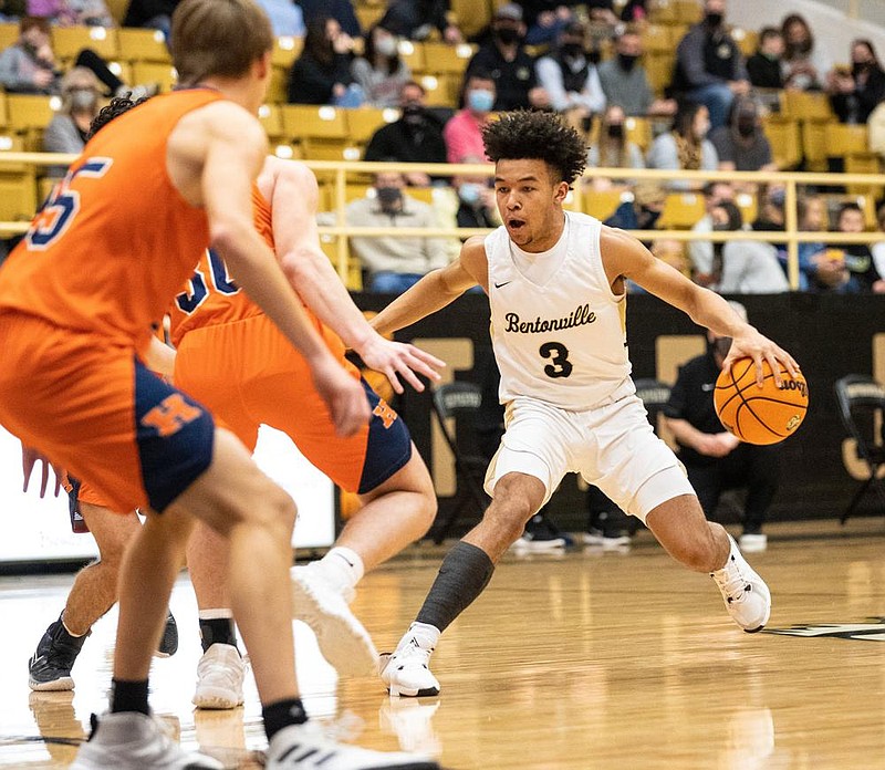 Bentonville sophomore Jaylen Lee (right) dribbles the ball Friday against two Rogers Heritage defenders during the Tigers’ 82-50 victory in Bentonville. Lee led the Tigers with 18 points.
(Special to the NWA Democrat-Gazette/David Beach)