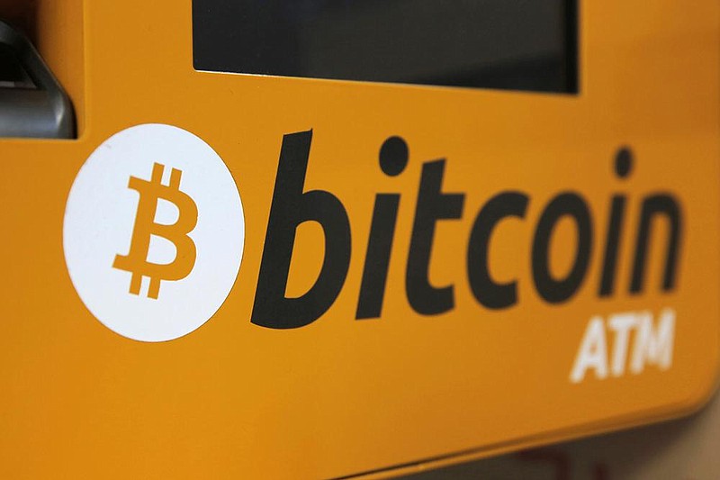 A Bitcoin logo is displayed on an ATM in Hong Kong in this 2017 file photo. Tesla says it has in- vested more than $1 billion in Bitcoin and will accept the digital currency as payment for its electric vehicles.
(AP)