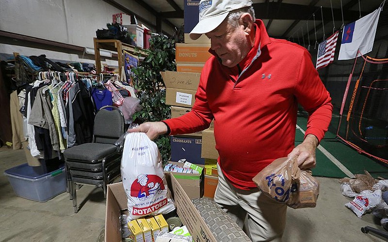 Mike Ross puts together a food box Wednesday at the Veterans Villages Helping Hand Program Food Pantry in North Little Rock.
(Arkansas Democrat-Gazette/Thomas Metthe)