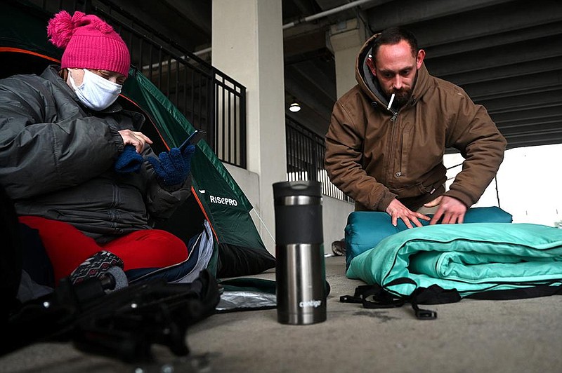 Jenifer Cloud, 37, and her fiancÈ Alax Young, 31, pack up their tent as they prepare to go to the warming shelter for the night on Tuesday, Feb. 9, 2021.

(Arkansas Democrat-Gazette/Stephen Swofford)