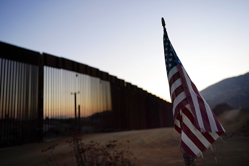 A flag sits just north of a section of the U.S.-Mexico border wall near Tecate, Calif., in this Sept. 24, 2020, file photo.