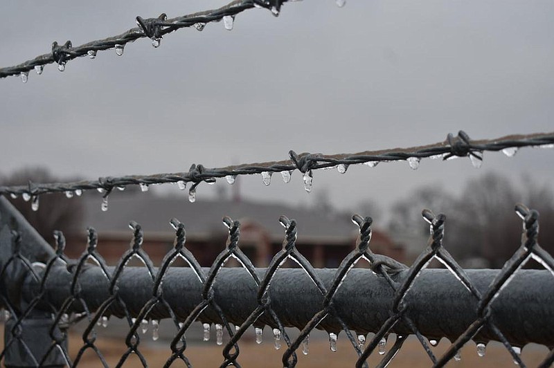 A fence built up ice overnight into Thursday on Marion Drive at Fluker Avenue with Robert F. Morehead Middle School in the Dollarway School District in the background. 
(Pine Bluff Commercial/I.C. Murrell)