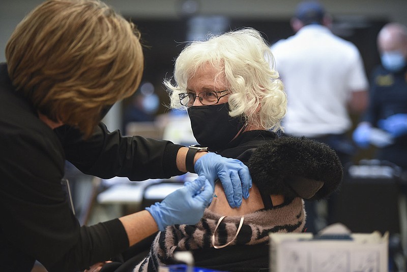 Registered nurse Wendy Broughton (left) administers a covid-19 vaccine Friday to Joyce Hurst of Bentonville at Riordan Hall in Bella Vista. Community paramedics from the Bella Vista Fire Department administered second doses of the vaccine to people in the 1-B category. Go to nwaonline.com/210213Daily/ for today’s photo gallery.
(NWA Democrat-Gazette/Charlie Kaijo)