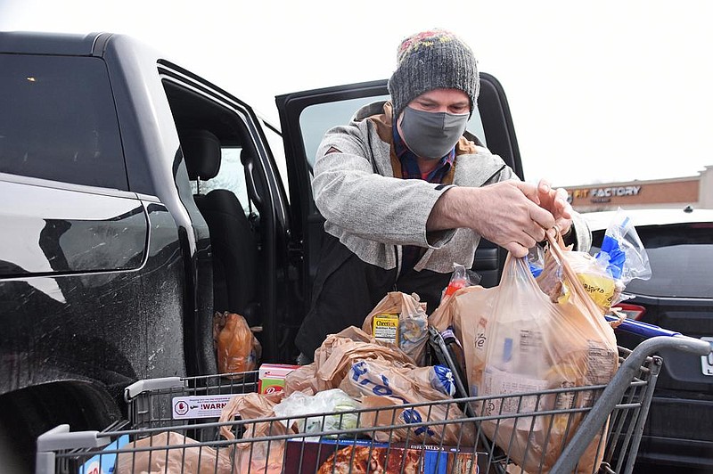 Brad Lawson loads groceries into his truck Saturday at the Kroger store on Chenal Parkway in Little Rock. Lawson said his family bought more groceries than usual to prepare for the winter weather.
(Arkansas Democrat-Gazette/Staci Vandagriff)