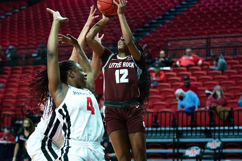 UALR guard Tia Harvey (12) shoots over two Arkansas State defenders Friday during the Trojans’ 70-63 victory over the Red Wolves at First National Bank Arena in Jonesboro. Harvey tied for the team lead with 14 points.
(Photo courtesy UALR Athletics)