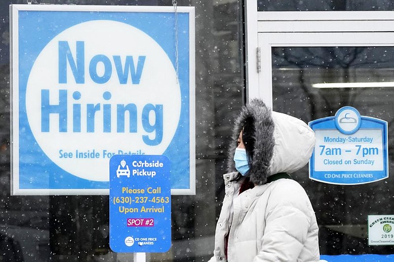 A now-hiring sign is displayed at a dry cleaner in Schaumburg, Ill., earlier this month. As the recession wears on, 9 million fewer people are working, but wages and salaries for those who have jobs have returned to the level they were before the pandemic.
(AP)