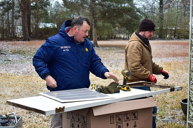 John Pyland (left), owner of SEARK Heating and Air, and Kyle Witt, a technician, set up a new heating unit Friday for installation at a Pine Bluff residence. 
(Pine Bluff Commercial/I.C. Murrell)