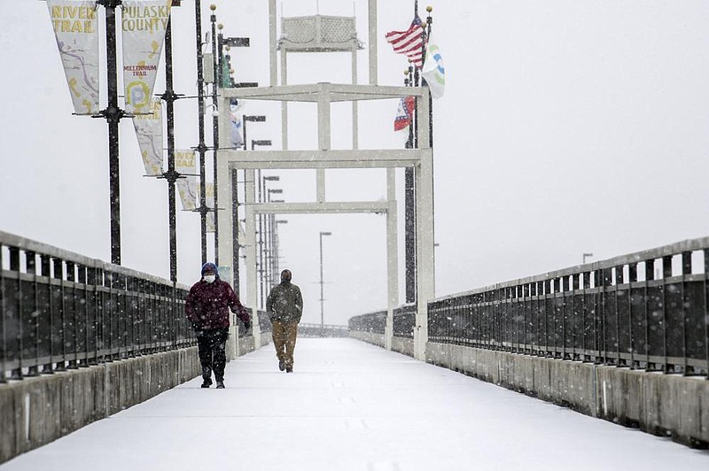 Lisa Parr, left, walks across the Big Dam Bridge with her son Troy Parr, 17, during a snowstorm on Sunday, Feb. 14, 2021. "This was the 17-year-old's idea" Lisa said. The National Weather Service issued a winter-storm warning for the entire state, predicting 5 inches or more of snow Sunday and Monday. See more photos at arkansasonline.com/215weather/

(Arkansas Democrat-Gazette/Stephen Swofford)