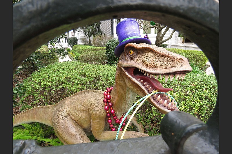 A top-hatted dinosaur is among Mardi Gras decorations in the yard of a mansion on St. Charles Avenue in New Orleans. (AP Photo/Janet McConnaughey)