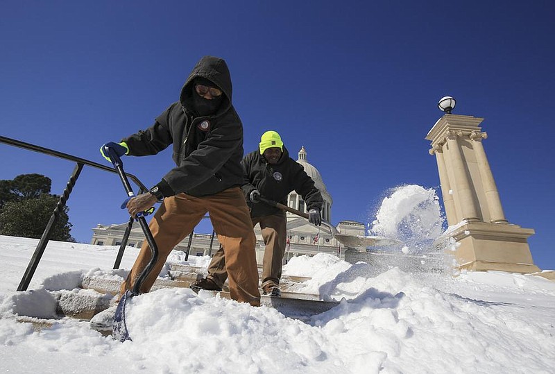 Anthony Armstrong, right, and Donnovan Moore with the Secretary of States Office work Tuesday Feb. 16, 2021 in Little Rock clearing snow of the steps at the state Capitol. More photos at arkansasonline/217snow/. (Arkansas Democrat-Gazette/Staton Breidenthal)