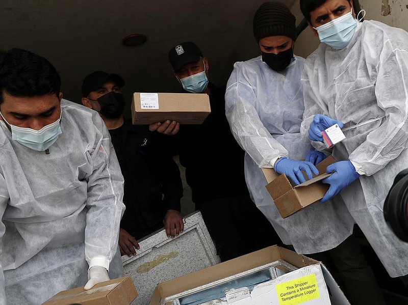 Medics and police officers check a shipment of the Russian Sputnik V vaccine Wednesday inside a truck at the Kerem Shalom border crossing in Rafah, Gaza Strip.
(AP/Adel Hana)
