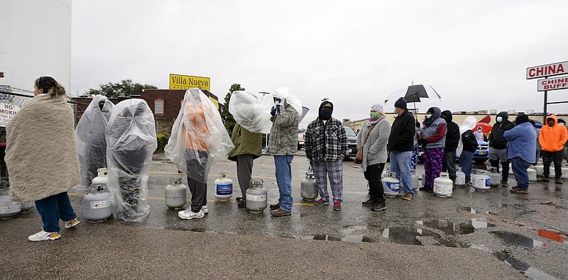 People wait in line to fill propane tanks Wednesday, Feb. 17, 2021, in Houston. Customers had to wait over an hour in the freezing rain to fill their tanks. Millions in Texas still had no power after a historic snowfall and single-digit temperatures created a surge of demand for electricity to warm up homes unaccustomed to such extreme lows, buckling the state's power grid and causing widespread blackouts. (AP Photo/David J. Phillip)