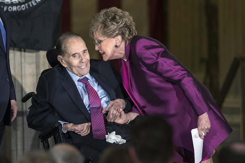 In this Jan. 17, 2018 file photo, former Senate Majority Leader Bob Dole smiles as he gets a kiss from his wife Elizabeth Dole as he is honored with a Congressional Gold Medal, at the Capitol in Washington. Political icon and 1996 Republican presidential nominee Bob Dole says he has been diagnosed with stage 4 lung cancer. The 97-year-old former U.S. Senate majority leader said Thursday in a short statement that he would begin treatment for the disease Monday.  (AP Photo/J. Scott Applewhite)