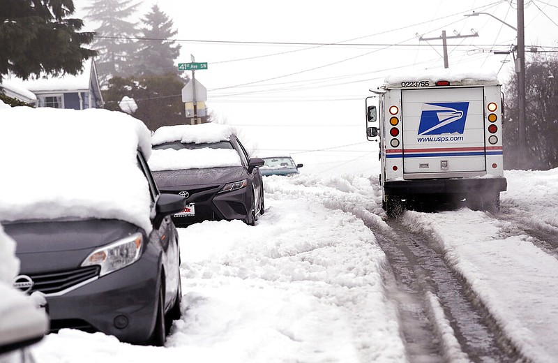 A U.S. Postal Service vehicle maneuvers up a Seattle street as snow turns to slush in this Feb. 12, 2019, file photo.
