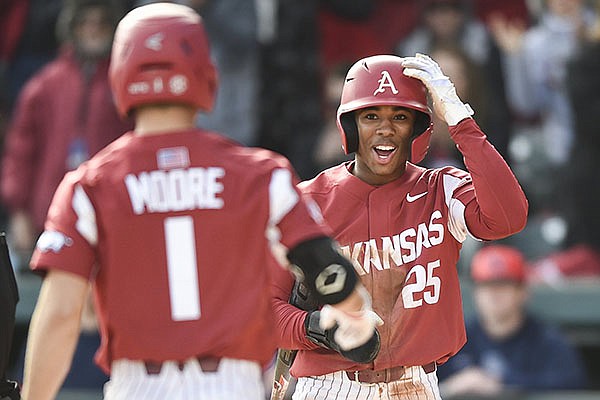 Arkansas center fielder Christian Franklin (25) waits at home plate for second baseman Robert Moore after Moore hit a home run during a game against Gonzaga on Saturday, Feb. 22, 2020, in Fayetteville. Franklin and Moore are among five Razorbacks from Kansas City, an area with increasing recruiting significance to Arkansas' baseball program. 