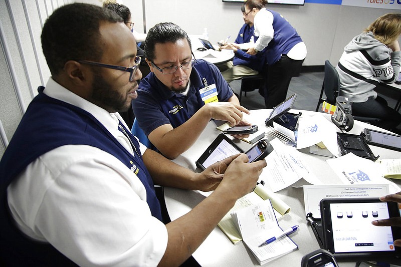 Walmart employees Kenneth White (left) and Marvin Toc work together using an inventory app while participating in a class at the Walmart Academy at the store in North Bergen, N.J., in this Thursday, Nov. 9, 2017, file photo.