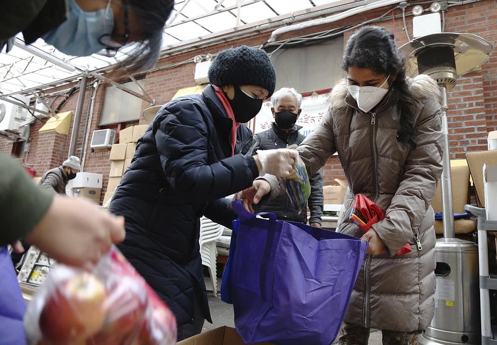 United Sherpa Association treasurer Tshering Sherpa (center) helps college students Jyoti Rajbanshi of Long Island University (left) and Lalsa Pandit of Laguardia Community College (right) pack free food in bags during the group’s weekly food pantry in the Queens borough of New York.
(AP/Jessie Wardarski)