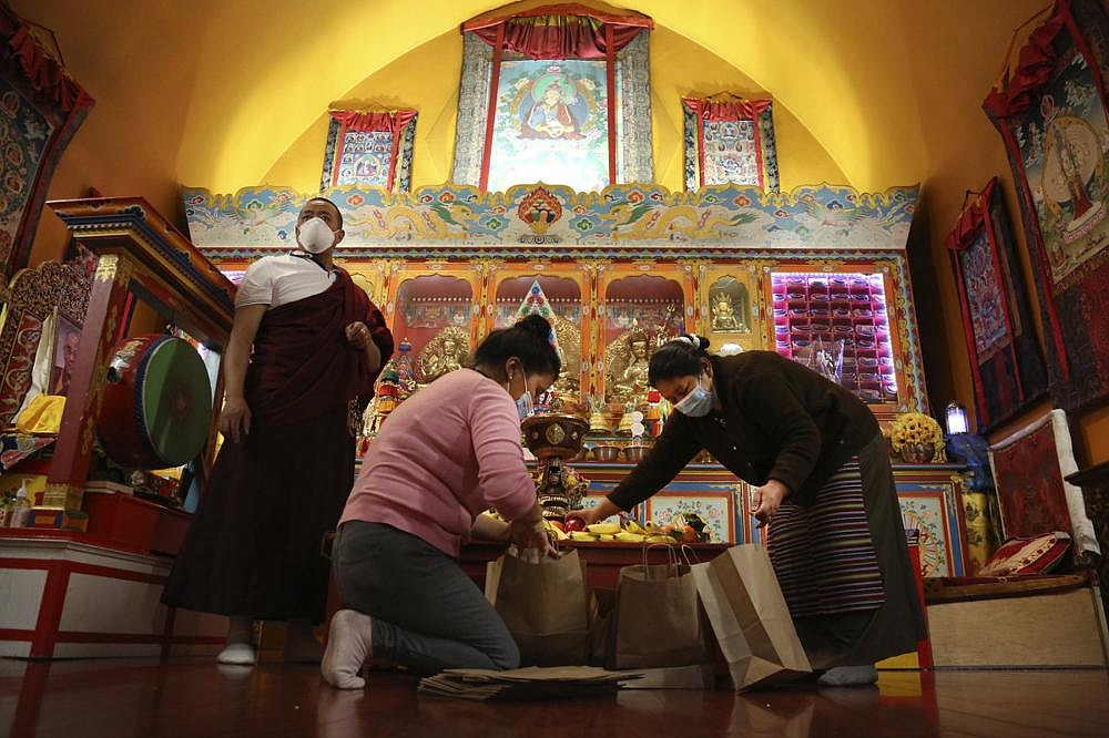 Lama Gelbu (left), Pasang Sherpa (center) and Yanddu Lama (right) prepare bags of fruit used as ceremonial offerings at the conclusion of the Dakini Day practice, a group meditation that includes song and food and is celebrated on the 25th day of each lunar month, at the United Sherpa Association in the Queens borough of New York.
(AP/Jessie Wardarski)