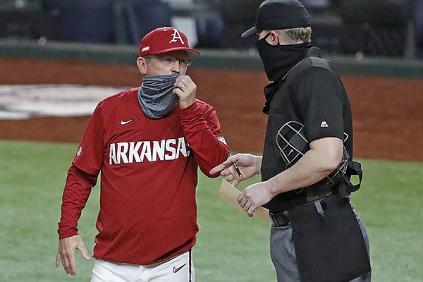 Arkansas coach Dave Van Horn (left) speaks with home plate umpire Seth Buckminster prior to a game against Texas on Sunday, Feb. 21, 2021, in Arlington, Texas. 