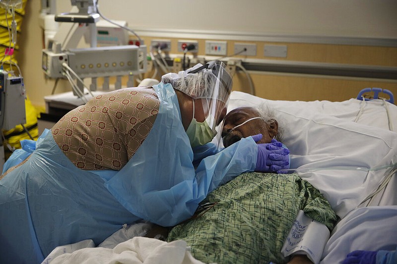 FILE - In this July 31, 2020, file photo, Romelia Navarro, 64, weeps while hugging her husband, Antonio, in his final moments in a covid-19 unit at St. Jude Medical Center in Fullerton, Calif. 