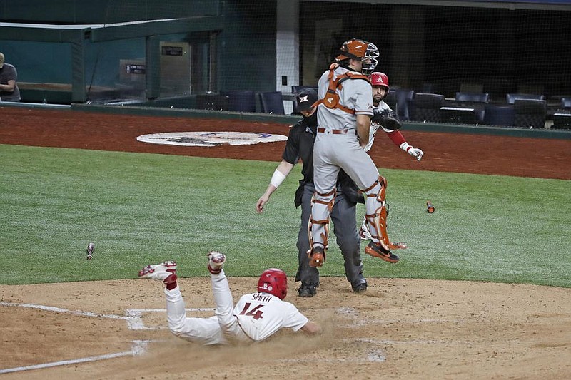 21 February 2021:   First baseman Cullen Smith (14)  of the Arkansas Razorbacks scores the first run on Brady Slavens hit during their game against Texas during the 2021 State Farm College Baseball Showdown baseball game at Globe Life Field in Arlington, Texas.  Photo by James D. Smith
