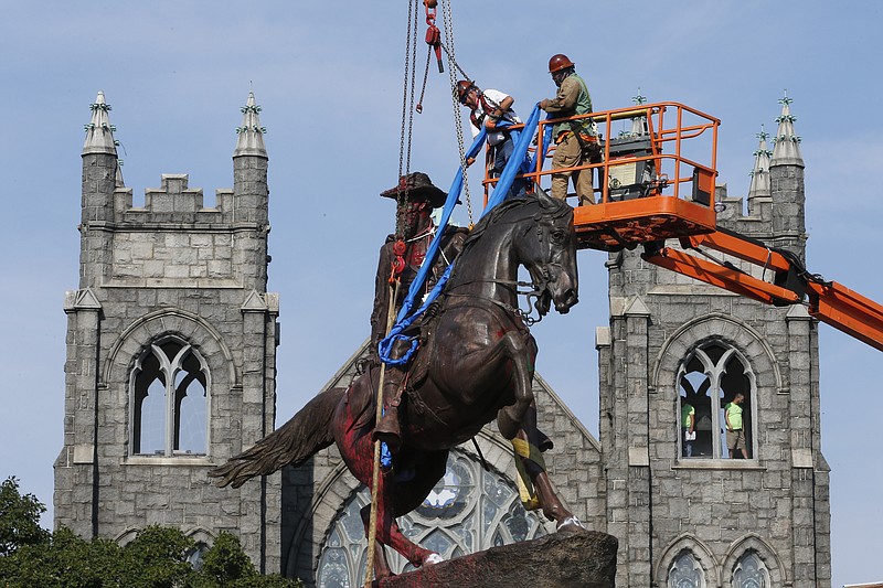 FILE - In this July 7, 2020, file photo, crews attach straps to the statue Confederate General J.E.B. Stuart on Monument Avenue in Richmond, Va. At least 160 Confederate symbols were taken down or moved from public spaces in 2020. That's according to a new count the Southern Poverty Law Center shared with The Associated Press. (AP Photo/Steve Helber, File) story.lead_photo.caption