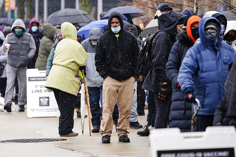 FILE - In this Feb. 19, 2021, file photo, people wait in line at a 24-hour, walk-up covid-19 vaccination clinic hosted by the Black Doctors Covid-19 Consortium at Temple University's Liacouras Center in Philadelphia. States are scrambling to catch up on coronavirus vaccinations after bad weather last week led to clinic closures and shipment backlogs. (AP Photo/Matt Rourke, File)