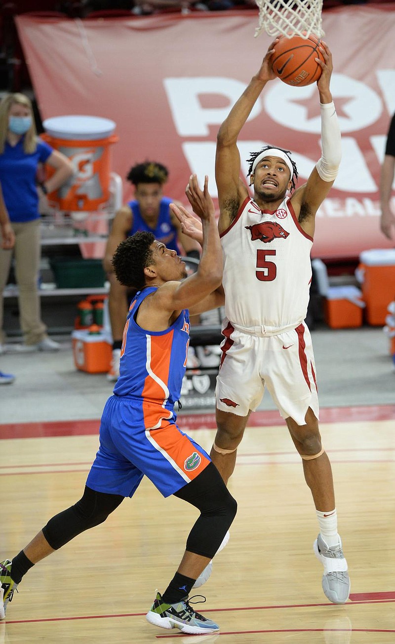 Arkansas guard Moses Moody (5) pulls down a rebound Tuesday, Feb. 16, 2021, as Florida guard Noah Locke (left) defends during the first half of play in Bud Walton Arena. Visit nwaonline.com/210217Daily/ for today's photo gallery. 
(NWA Democrat-Gazette/Andy Shupe)