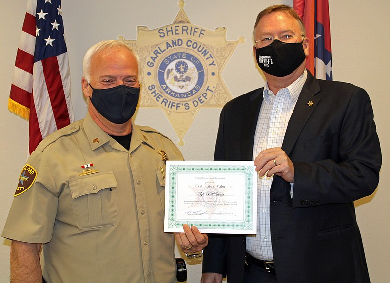 Garland County sheriff’s Sgt. Bill House, left, receives a Certificate of Valor from Sheriff Mike McCormick Wednesday at the sheriff’s department for using a tourniquet to help save a shooting victim. -  Photo by Tanner Newton of The Sentinel-Record