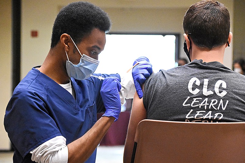 Arthur Shaw, a pharmacy intern for Don’s Pharmacy, administers a covid-19 vaccine Wednesday, Feb. 24, 2021, during a vaccine clinic for University of Arkansas at Little Rock employees in the Donaghey Student Center. (Arkansas Democrat-Gazette/Staci Vandagriff)