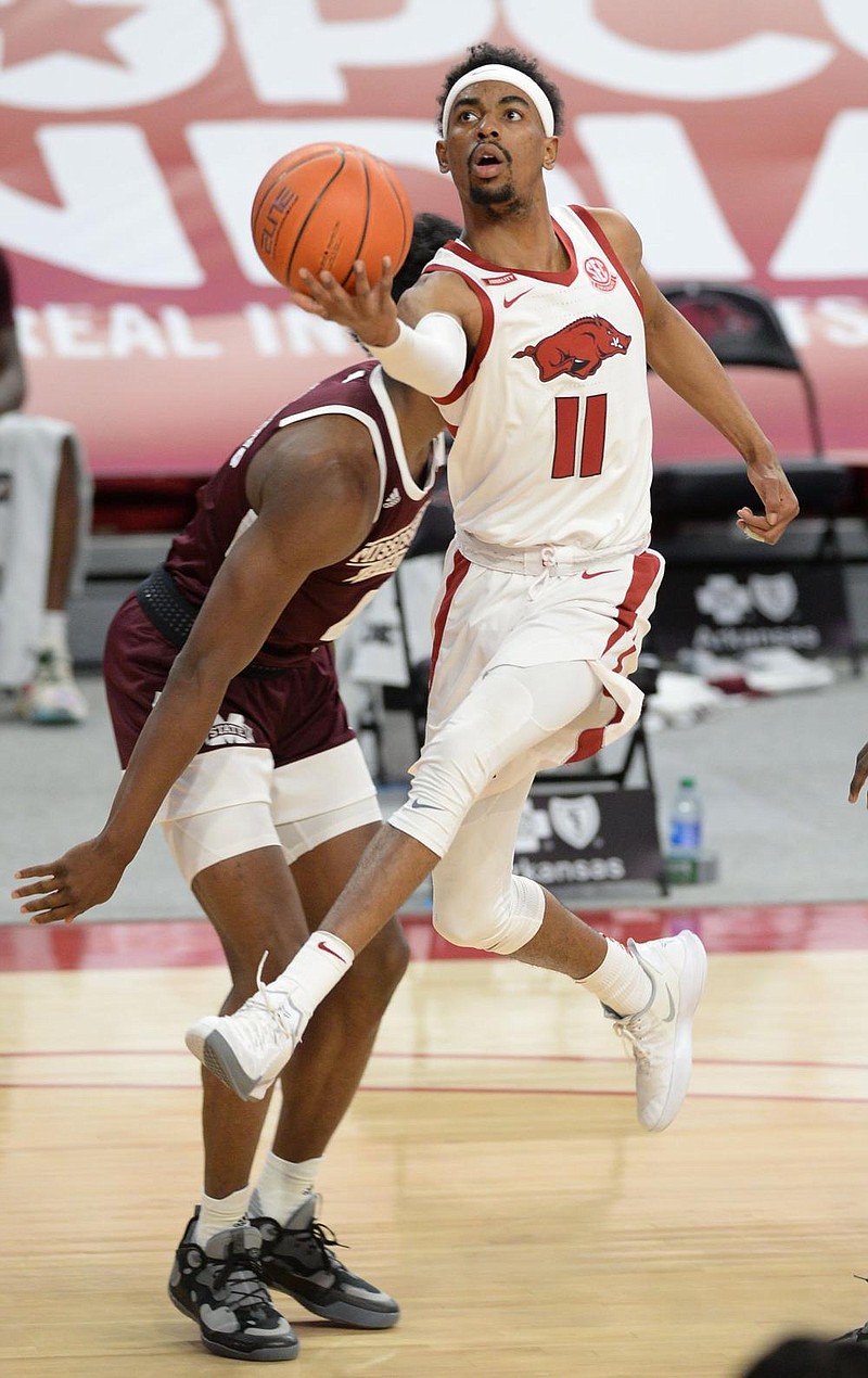 Arkansas guard Jalen Tate (11) reaches to score in the lane Tuesday, Feb. 2, 2021, past Mississippi State forward Abdul Ado during the first half of play in Bud Walton Arena in Fayetteville. Visit nwaonline.com/210203Daily/ for today's photo gallery.  