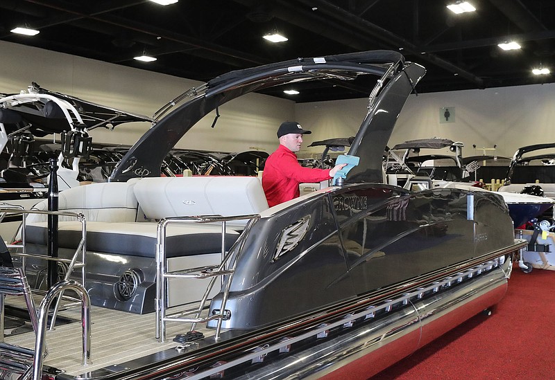 Gregg Orr Marine employee Brandon Lackey cleans one of the boats at the Hot Springs Convention Center Thursday in preparation for this weekend’s 35th Annual Hot Springs Boat & RV Show. - Photo by Richard Rasmussen of The Sentinel-Record