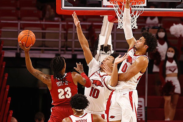 Arkansas forwards Jaylin Williams (10) and Justin Smith (0) attempt to block a shot from Alabama’s John Petty during a game Wednesday, Feb. 24, 2021, in Fayetteville.
(Photo by Kent Gidley via SEC Pool)