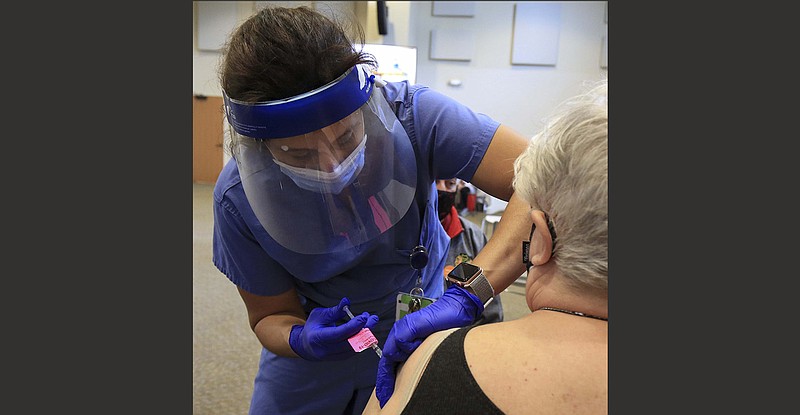 Nurse practitioner BarbaraMcDonald, left, gives Pauline Gerstein a covid vaccine shot Wednesday Feb. 25, 2021 at the UAMS vaccine clinic in Little Rock. Yesterday was the first day for the clinic to operate in its new location at the Centre at University Park at 6401 W. 12th Street.(Arkansas Democrat-Gazette/Staton Breidenthal)