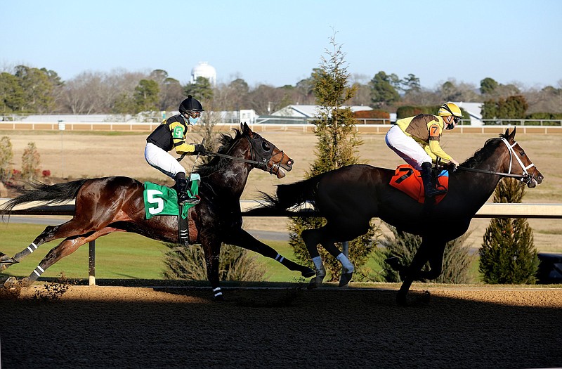 Caddo River, ridden by Florent Geroux, leads Hardly Swayed, ridden by Martin Garcia, going into the first turn during the Smarty Jones Stakes on Jan. 22 at Oaklawn in Hot Springs. Thursday was the first day of live racing since Feb. 11 with six stakes races scheduled for the weekend.
(Arkansas Democrat-Gazette/Thomas Metthe)