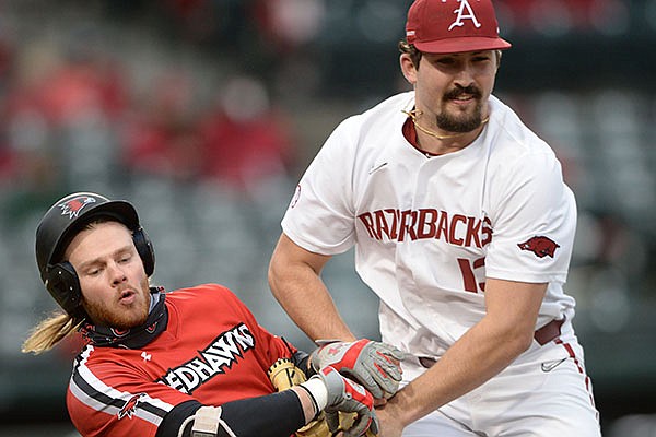 Arkansas reliever Connor Noland (right) collides Friday, Feb. 26, 2021, with Southeast Missouri State's Danny Wright as Wright is tagged out on his way to first during the sixth inning of the Razorbacks' 7-3 win at Baum-Walker Stadium in Fayetteville.