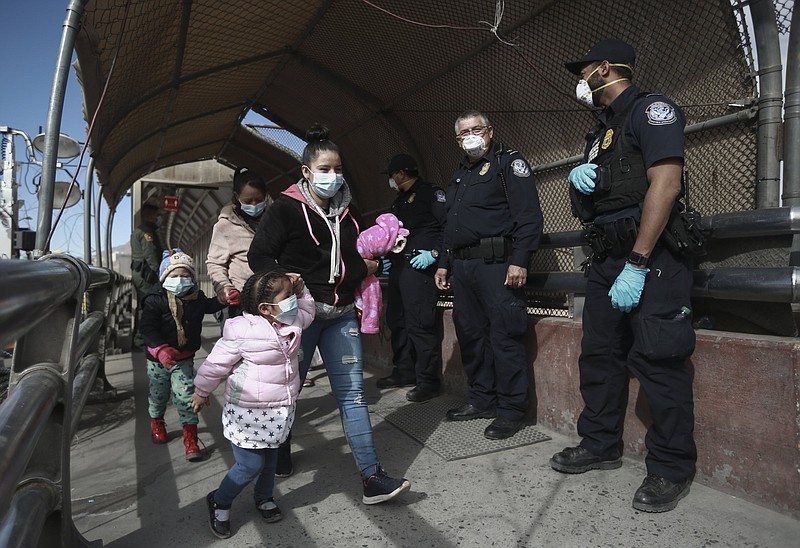 A migrant family crosses the border into El Paso, Texas, in Ciudad Juarez, Mexico, Friday, Feb. 26, 2021. After waiting months and sometimes years in Mexico, people seeking asylum in the United States are being allowed into the country as they wait for courts to decide on their cases, unwinding one of the Trump administration's signature immigration policies that President Joe Biden vowed to end. (AP Photo/Christian Chavez)