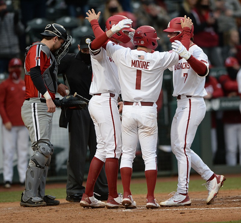 Arkansas right fielder Cayden Wallace (right) is congratulated at the plate Friday, Feb. 26, 2021, by second baseman Robert Moore (1) and first baseman Brady Slavens after hitting a two-run home run to score Moore against Southeast Missouri State during the sixth inning of the RazorbacksÕ 7-3 win at Baum-Walker Stadium in Fayetteville. Visit nwaonline.com/210227Daily/ for today's photo gallery. .(NWA Democrat-Gazette/Andy Shupe)