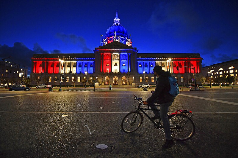 A bicyclist stops to admire the red, white and blue lights illuminating San Francisco City Hall in San Francisco, Calif., Friday, Nov. 6, 2020. Congress is beginning debate on the biggest overhaul of U.S. elections law in a generation. Legislation from Democrats would touch virtually every aspect of the electoral process — striking down hurdles to voting, curbing partisan gerrymandering and curtailing big money in politics. Republicans see those very measures as a threat that would limit the power of states to conduct elections and ultimately benefit Democrats. (Jose Carlos Fajardo/Bay Area News Group via AP, file)