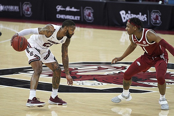 South Carolina guard Seventh Woods (23) is defended by Arkansas guard JD Notae (1) during the first half of an NCAA college basketball game Tuesday, March 2, 2021, in Columbia, S.C. (AP Photo/Sean Rayford)