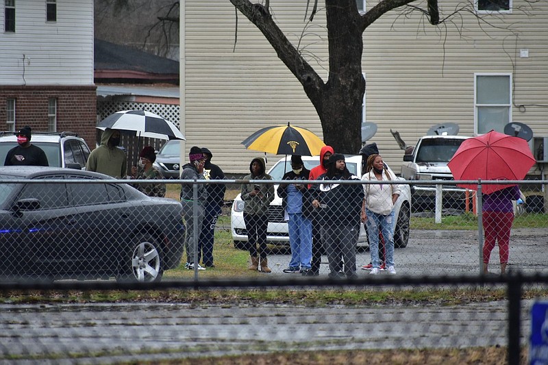 Bystanders look on from Sulphur Springs Road after a report of a shooting at Watson Chapel Junior High School on Monday, March 1, 2021. (Pine Bluff Commercial/I.C. Murrell)